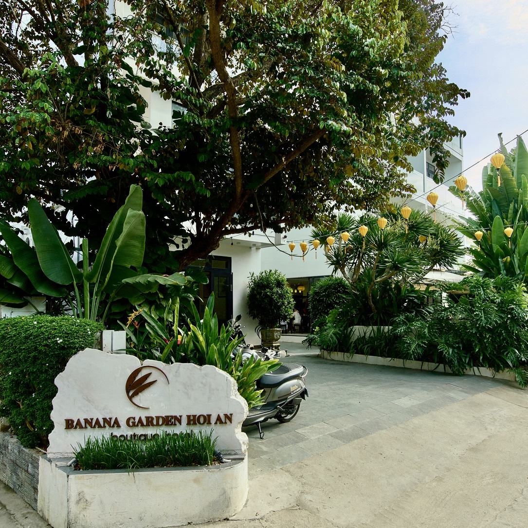 The Banana Garden Hoi An entrance sign among banana palms and lanterns