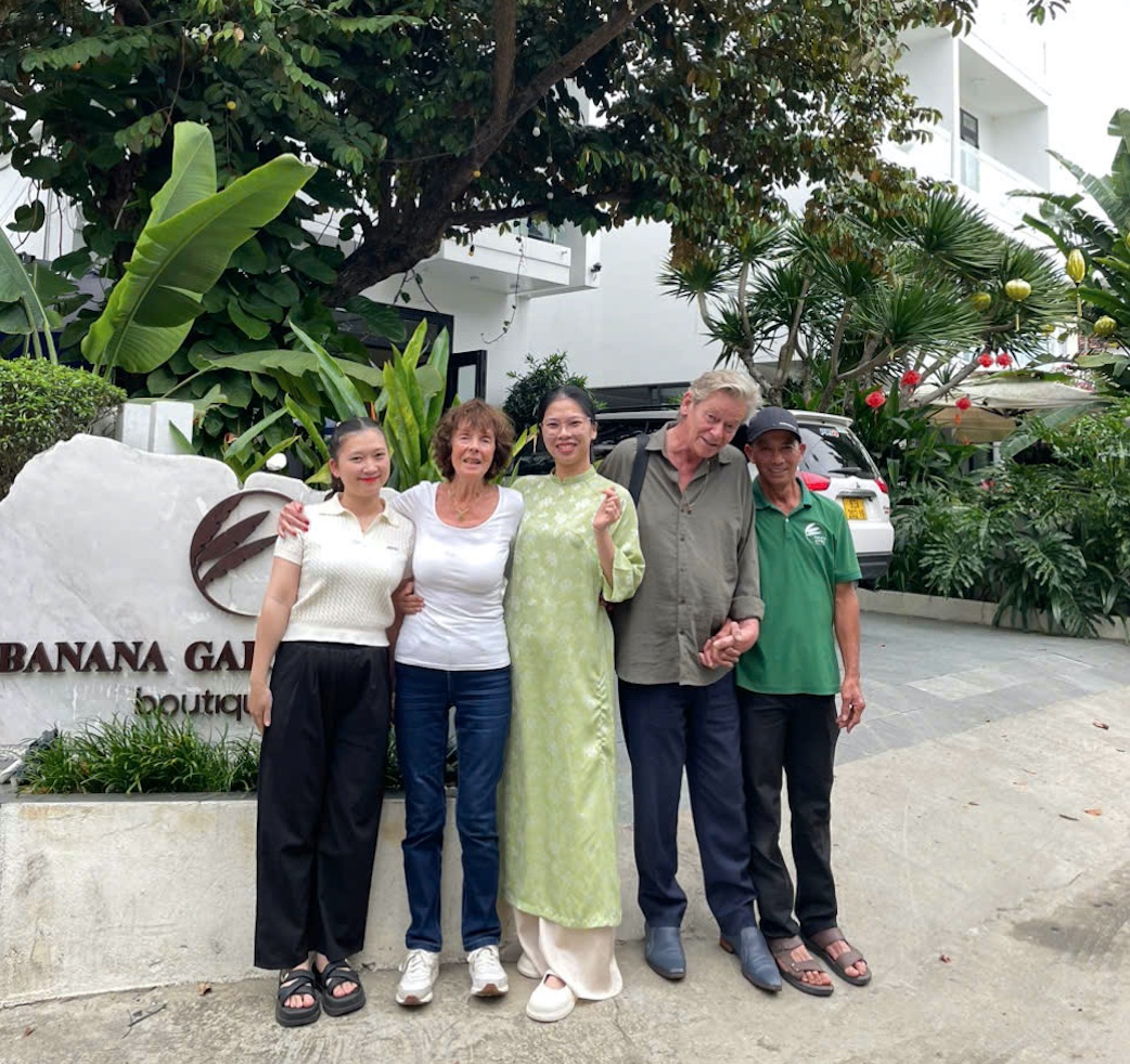 Guests and staff posing by the Banana Garden entrance sign